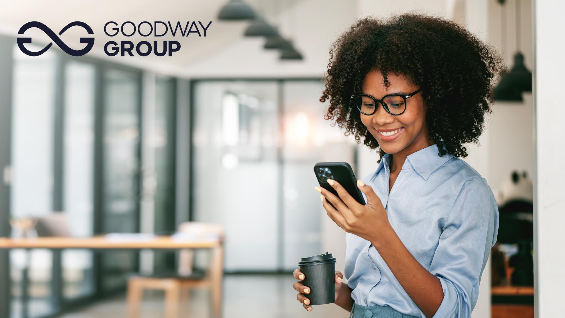 Picture shows a person busy on their phone while a holding cup of coffee. Goodway Group logo sits at the top right corner