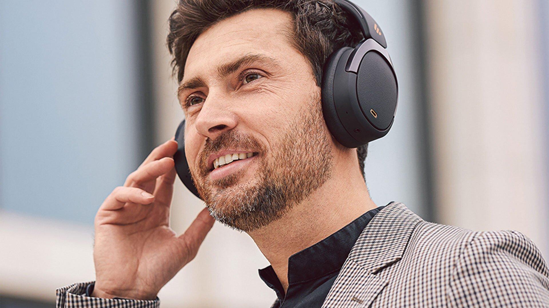 Picture shows a smiling man wearing headphones